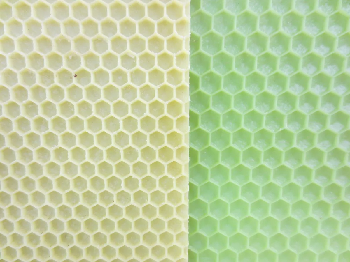 Two sheets of embossed comb foundation, one pale yellow and one green