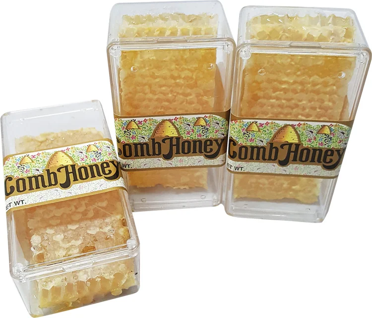 Clear plastic containers of cut comb honey with labels