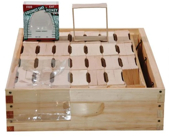 Wooden hive box holding rows of small wooden comb honey sections