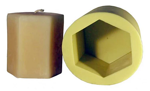 Tan hexagonal pillar candle beside the silicone mold it was made in
