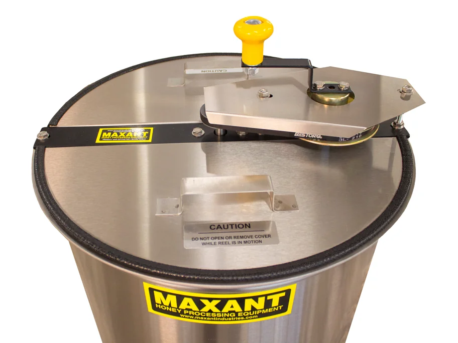 Stainless steel honey extractor seen from above, with a yellow knob on the lid