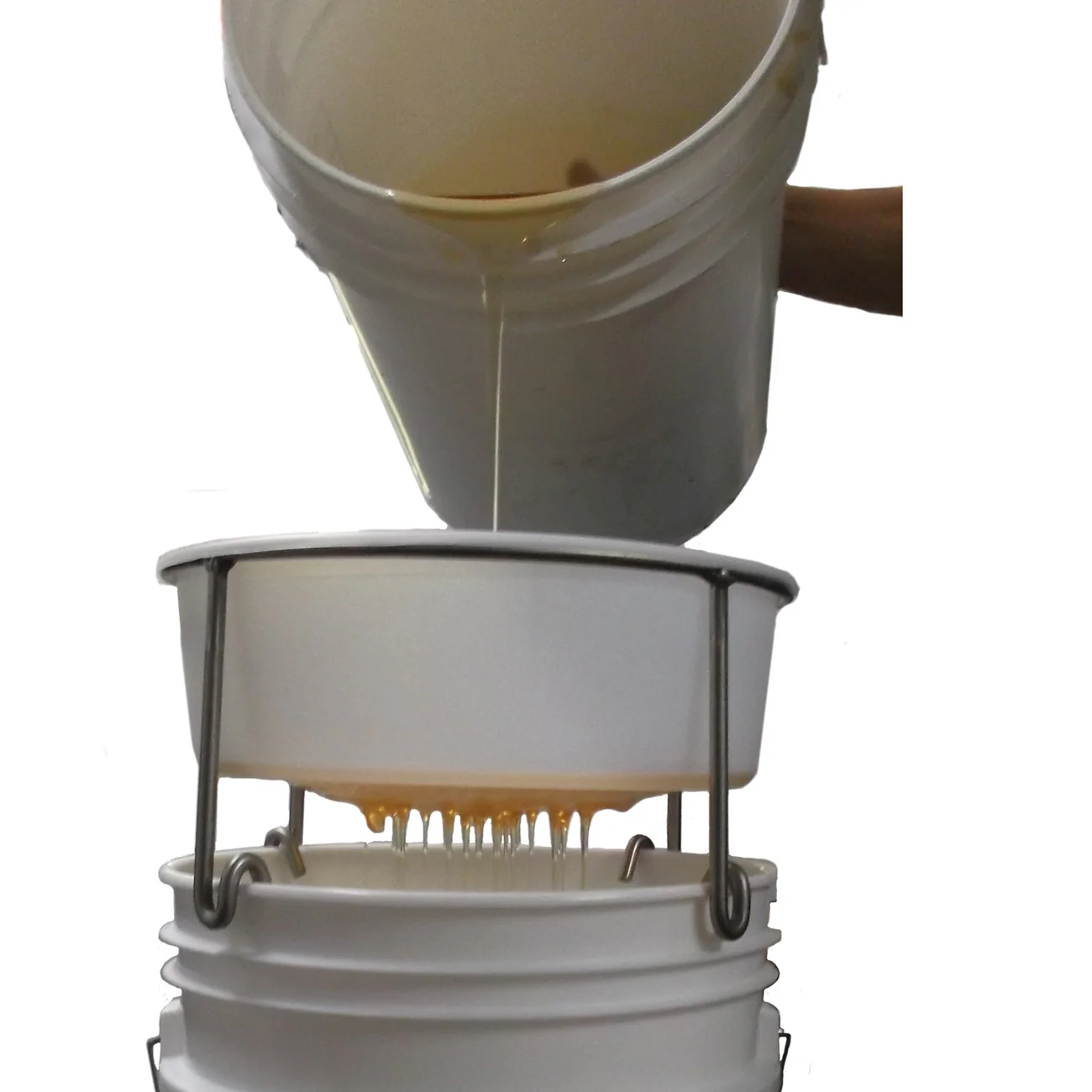 White bucket pouring honey through a filter held on a stand over a second pail