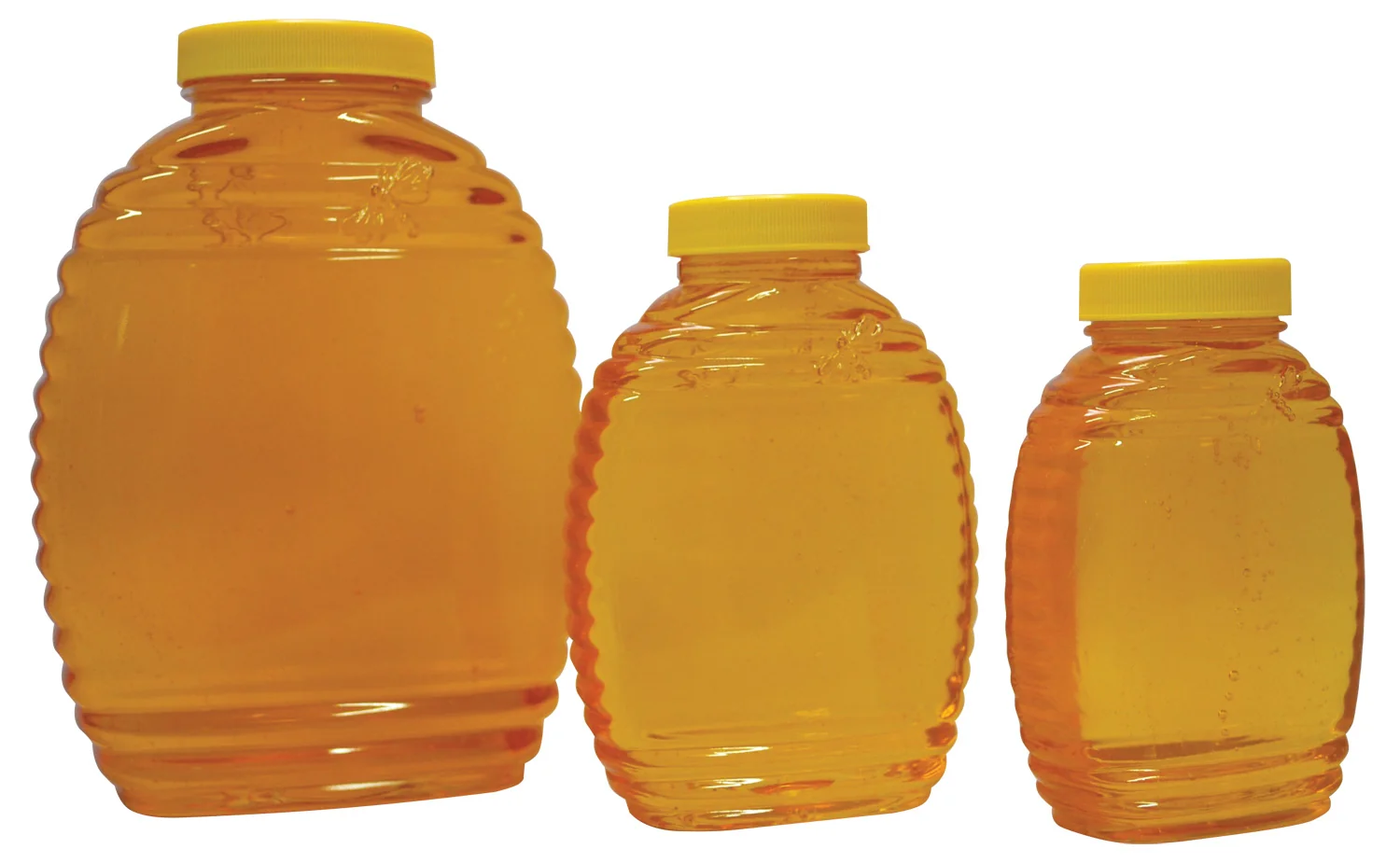 Three honey jars in different sizes filled with golden honey and capped with yellow lids